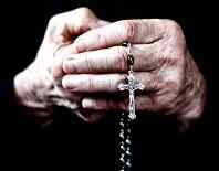 mani di prete con rosario